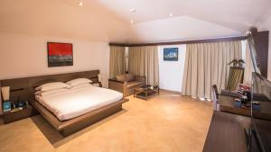 a bedroom with a bed and a desk and a television at Aamby Valley City in Lonavala