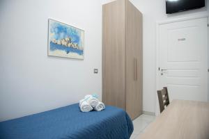 een slaapkamer met een blauw bed en een tafel bij Stabia Dream Rooms in Castellammare di Stabia