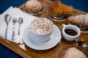 een dienblad met een kopje koffie en wat gebak bij Stabia Dream Rooms in Castellammare di Stabia