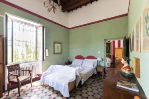 een slaapkamer met 2 bedden, een tafel en een raam bij Villa Le Pergole- Firenze in Florence