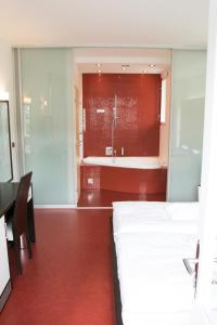 a bedroom with two beds and a bath tub at Hotel Krystal in Luhačovice