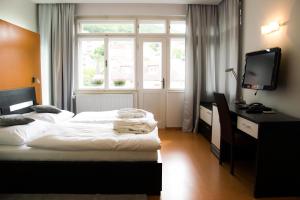 a hotel room with two beds and a television at Hotel Krystal in Luhačovice