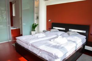 a large white bed in a room with an orange wall at Hotel Krystal in Luhačovice