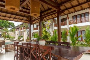 an outdoor patio with a wooden table and chairs at Ratan Uluwatu Hotel and Villas in Uluwatu