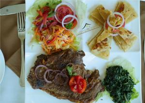 une assiette de nourriture avec steak, légumes et frites dans l'établissement Legacy Hotel and Conference Centre ltd, à Nakuru