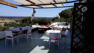 un patio con mesas y sillas blancas y vistas. en Villa delle torri, en Pula