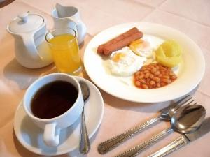 einen Tisch mit einem Frühstücksteller und einer Tasse Kaffee in der Unterkunft Terrace Hotel in Bandar Seri Begawan