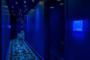 um corredor com luzes azuis e uma parede azul em Monsieur Jean - Hôtel Particulier em Quebeque