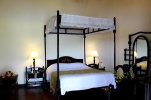 1 dormitorio con cama con dosel y espejo en Lake Palace, en Thekkady