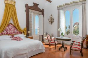 Schlafzimmer mit einem Bett, einem Tisch und Stühlen in der Unterkunft Hotel Palazzo Murat in Positano