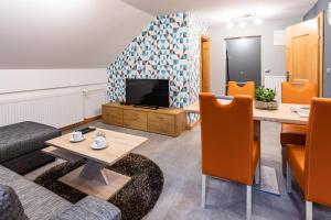 ein Wohnzimmer mit einem Tisch und einem TV in der Unterkunft Apartma Borovnica Rogla in Vitanje