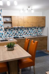 eine Küche mit einem Holztisch und orangefarbenen Stühlen in der Unterkunft Apartma Borovnica Rogla in Vitanje