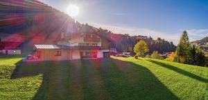 dom na polu, na którym świeci słońce w obiekcie Chalet Dumbria Dolomites w mieście Selva di Val Gardena