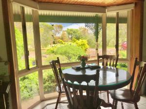 una sala da pranzo con tavolo e una grande finestra di Fairy Wren Cottage Country to Coast Retreat a Wallington