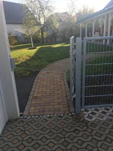 una puerta a una pasarela de ladrillo junto a una casa en Ferienwohnung Herbsleben, en Herbsleben