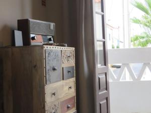 a dresser with a television on it next to a window at SEA URCHIN MILFONTES by Stay in Alentejo in Vila Nova de Milfontes