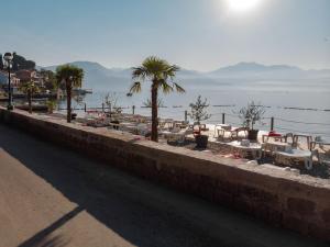 un mur avec des tables et des palmiers près de l'eau dans l'établissement Barka B'n'B - Elegant Seaview Rooms, à Herceg-Novi