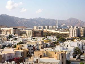 una ciudad con edificios y montañas en el fondo en ibis Muscat, en Mascate