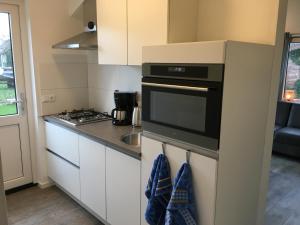 una piccola cucina con piano cottura e lavandino di Vakantiewoning 't Steechje a Hollum