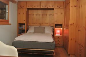 een slaapkamer met een bed in een houten kast bij Chalet Studio - Top Ausstattung - beste Lage Davos in Davos