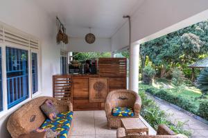 eine Veranda mit 2 Stühlen und einem Sofa in der Unterkunft Muti Entebbe in Entebbe