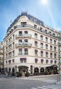 un gran edificio blanco con un reloj en él en Hôtel Château Frontenac, en París