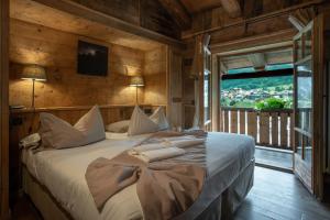 een slaapkamer met een groot bed in een kamer met een raam bij Chalet-hotel Svizzero in Courmayeur