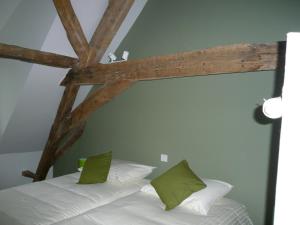 a bed with two green pillows in a room at Apartment Het Blekershuys in Bruges