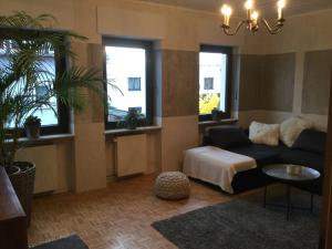 a living room with a couch and two windows at Beletage in Neuwied