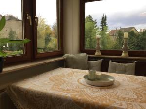 a dining room table with a plate on it and two windows at Beletage in Neuwied