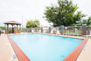 uma grande piscina com cadeiras e um gazebo em Palacio Royale Inn Signature Katy em Katy