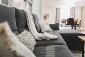 a living room with a gray couch with towels on it at Hissla Riquewihr Le Schlupf & La Perle in Riquewihr