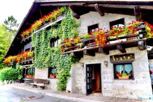 un edificio con flores a un lado. en Albergo Ristorante Al Fratè da Streza, en Madonna di Campiglio