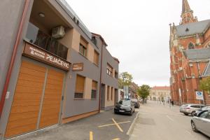 een gebouw met een garage aan de straatkant bij Apartmani i sobe Pejačević in Osijek