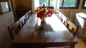 una mesa de madera con un jarrón de flores. en Casa Rural Casona de Jerte, en Jerte