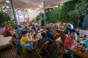 eine Gruppe von Personen, die in einem Restaurant an Tischen sitzen in der Unterkunft America Del Sur Hostel Buenos Aires in Buenos Aires