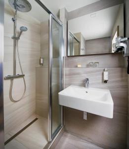 bagno con lavandino e doccia di OREA Hotel Pyramida Praha a Praga