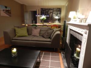 a living room with a couch and a fireplace at Apartment Het Blekershuys in Bruges