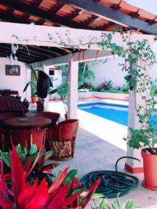 a patio with a pool and a table and some plants at Casa las Flores in Puerto Vallarta