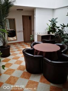 a room with chairs and a table and some plants at The Corner House Panzió in Tata