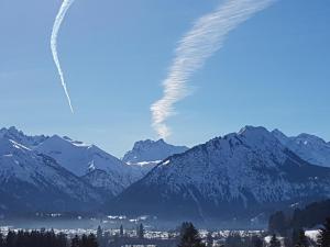 un jet survole une chaîne de montagnes enneigée dans l'établissement Landhaus Eggensberger, à Fischen im Allgäu