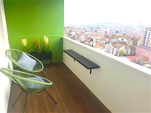 een groene kamer met een balkon met een bank en een raam bij Kristall Apartments 2 Panorama in Šabac