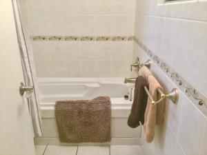 a bathroom with a bath tub and a sink at Burley's Executive Garden Suite in Peterborough