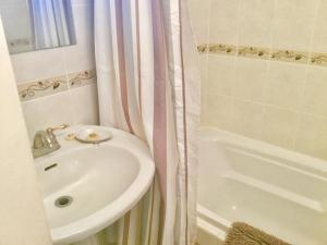 a bathroom with a sink and a shower curtain at Burley's Executive Garden Suite in Peterborough