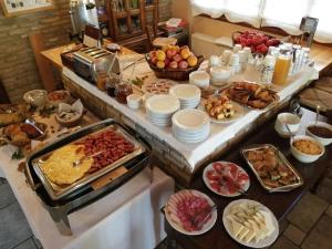 un buffet con tavolo pieno di diversi tipi di cibo di Mysaion Hotel a Synikia Mesi Trikalon