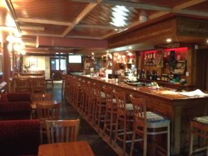 een bar in een restaurant met houten stoelen bij Glendine Inn in Kilkenny