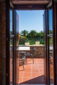 una puerta de cristal que da a un patio con mesa y sillas en Ktima Petalea, en Gythio