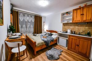 Cette chambre comprend un lit, une table et une cuisine. dans l'établissement Willa Bachledówka, à Zakopane