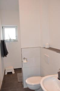 a white bathroom with a toilet and a sink at LaVaTe in Kappel-Grafenhausen