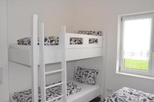 two bunk beds in a white room with a window at LaVaTe in Kappel-Grafenhausen